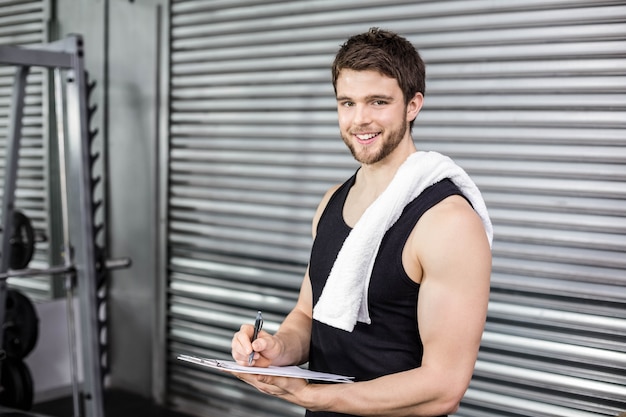 Foto trainer maken van aantekeningen op sportschool