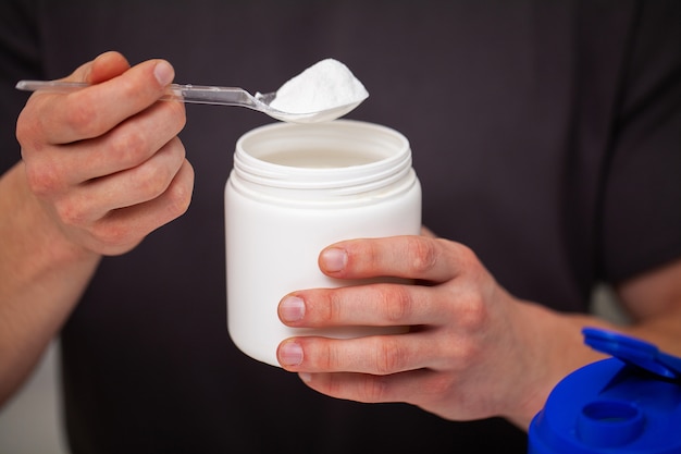 L'allenatore prepara un frullato di proteine nello shaker dopo l'allenamento