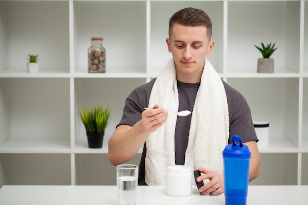 L'allenatore prepara un frullato di proteine nello shaker dopo l'allenamento