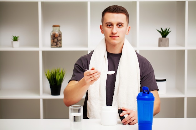 Trainer prepares a protein shake in the shaker after training.