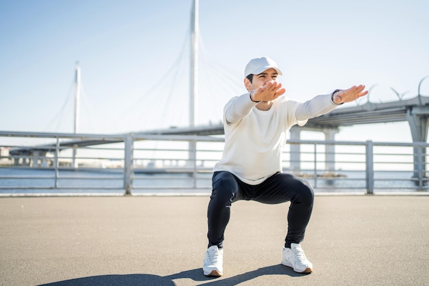 The trainer sports man training in sportswear on the street exercises that develop cardio bodies