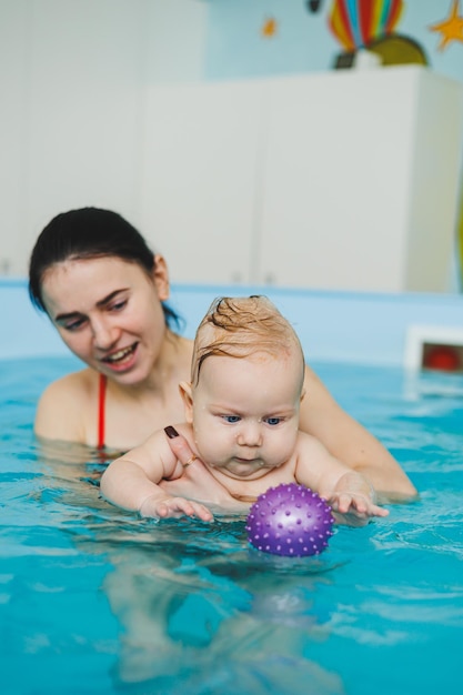 トレーナーが赤ちゃんに水泳を教える 子供のためのプール 子供の発達