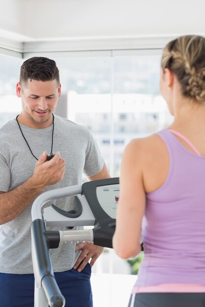 Foto allenatore guardando la donna che esercitano in palestra