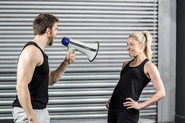 Фото Тренер кричит через мегафон в тренажерном зале crossfit