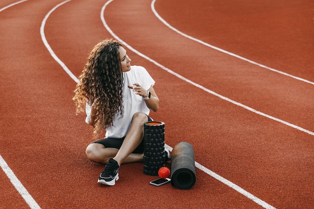 Trainer zit in een stadion in de buurt van haar trainingsapparatuur.