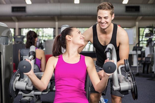 Trainermens die atletische vrouw helpen bij gymnastiek