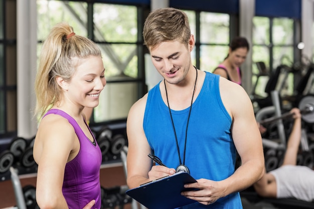 Trainermens die met sportvrouw in gymnastiek spreekt