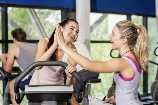 Trainervrouw en sportvrouw high-fiving bij gymnastiek