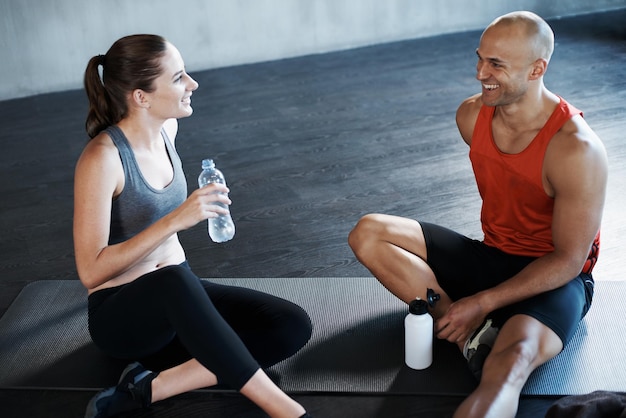 Training to become fighting fit. Shot of a man and woman taking a break after a workout at the gym.