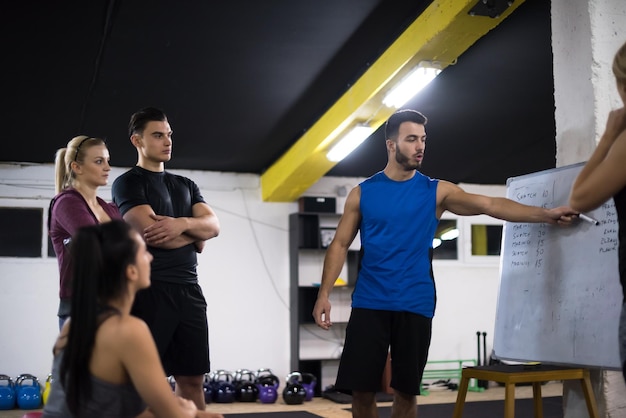 Foto training course.group van jonge atleten die instructies krijgen van de trainer voordat ze gaan sporten bij cross fitness gym