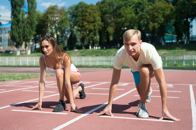 Training en gezondheid, sportpaar begint competitie op arenabaan zonnige zomer buiten