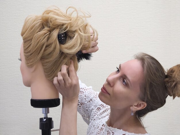 Training haarstyling op een mannequin.