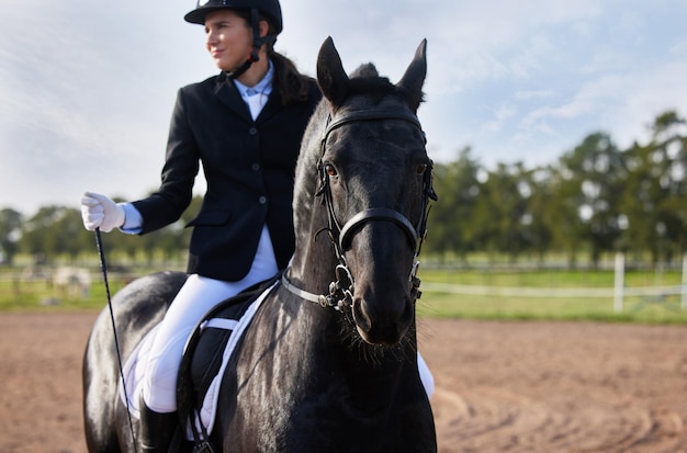 馬に乗ったトレーニングクロップドは、農場で馬に乗っている魅力的な若い女性騎手を撃ちました