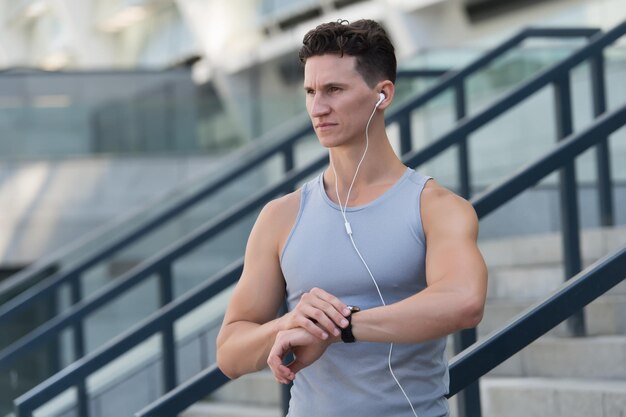 Training and lifestyle concept. Runner with heart rate monitor sports smart watch. looking at watch. Training Hard outside of Gym. wrist-based heart rate monitor. Checking the running time.