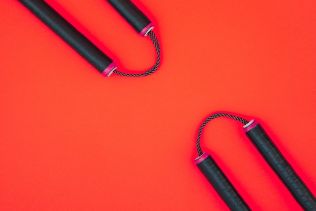 Training nunchaku isolated on a red surface