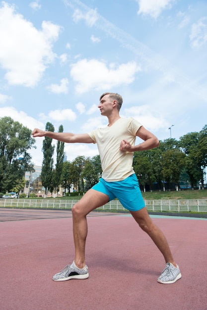 Training van man die zonnig buiten op blauwe lucht sport en fitness ponst