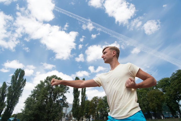 Training van man die zonnig buiten op blauwe lucht sport en fitness ponst