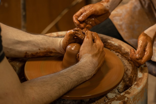 Training for work in the potters wheel a man and a woman work together with clay