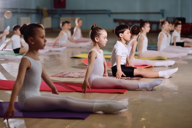 Тренировка молодых танцоров в балетной студии.