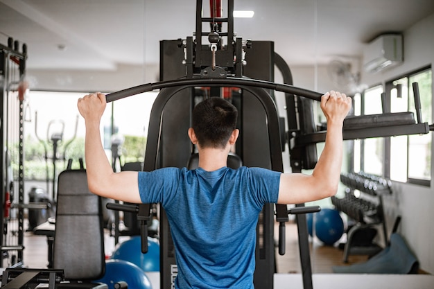 Trainingsgymnastiekconcept een mannelijke tiener die fitnessapparatuur gebruikt