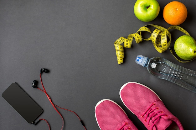 Foto trainingsplan met fitness eten en apparatuur op grijze achtergrond bovenaanzicht