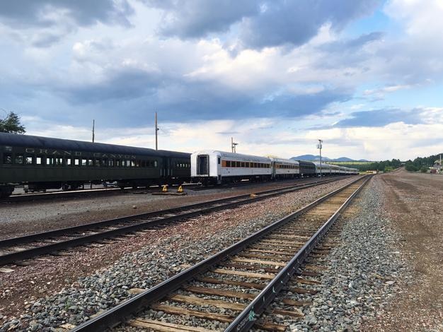 雲の空に照らされた鉄道線路の列車