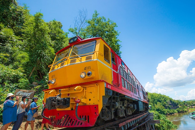 trains running on death railways track crossing kwai river in kanchanaburi