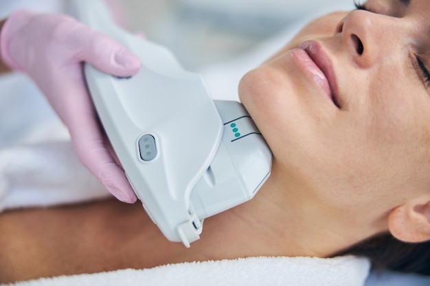 Photo tranquil lady enjoying a skin rejuvenation procedure conducted by a cosmetologist