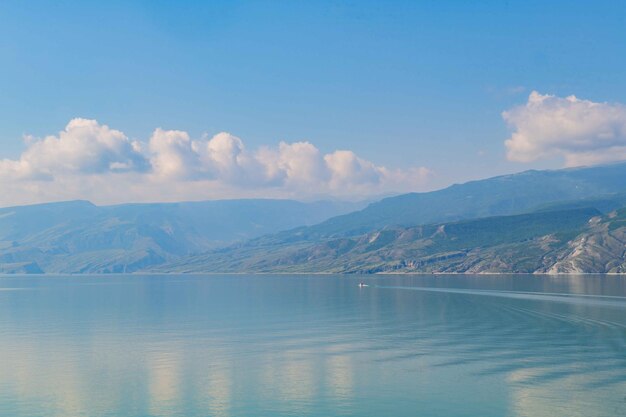 Tranquil mountain lake beautifully contrasted by the blue sky and peaks