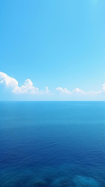 Tranquil sea harmony Blue sky over serene waters with reflection Vertical Mobile Wallpaper