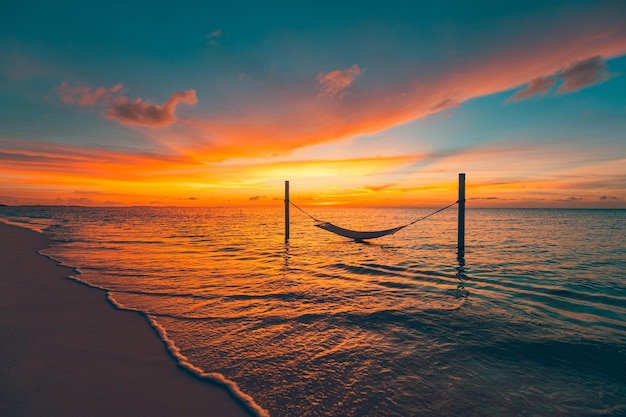 Tranquil summer vacation or holiday landscape Tropical sunset beach swing amazing sky seascape