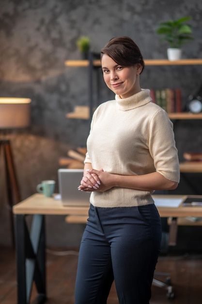 Tranquil young woman posing for the camera against her desk