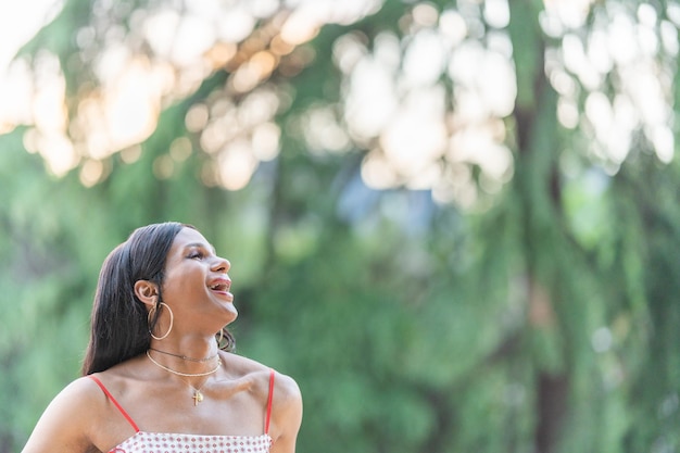 Trans woman looking up while laughing in the nature