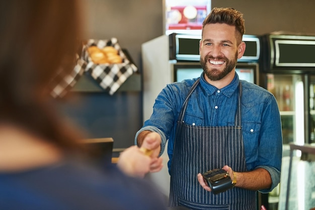 Transacties snel en gemakkelijk gemaakt Bijgesneden opname van een ober die een creditcardbetaling van een klant accepteert