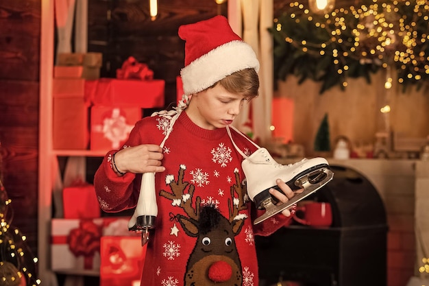 Transform your shoes into ice skates for Winter New year party Christmas mood concept Santa claus kid Happy winter holidays Christmas coming Small boy Little boy child in santa red hat