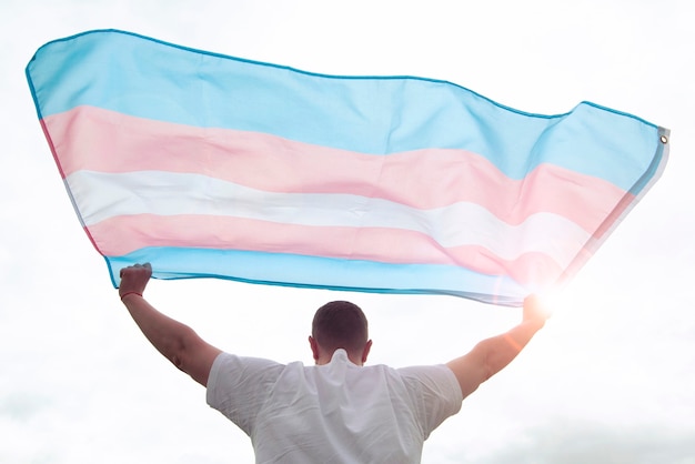 Transgender man holding waving transgender flag, concept picture about human rights, equality in the World