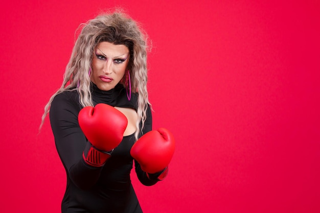 Foto persona transgender con guantoni da boxe e posa aggressiva