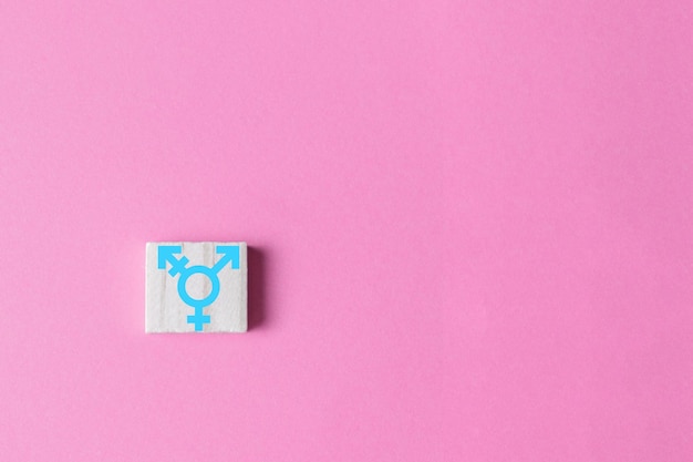 Transgender symbool op houten blok op roze achtergrond Transgender rechten concept