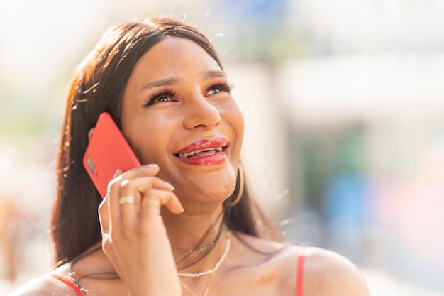 Transgender vrouw die lacht terwijl ze buiten met de mobiel praat