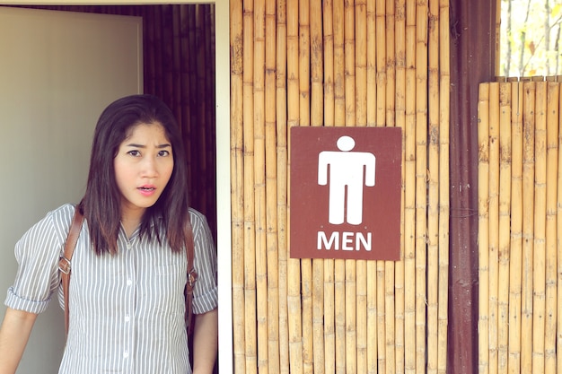Photo transgender woman leave from the men's toilet looking straight and upset