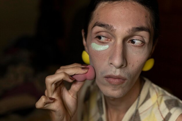 A transgender young man 22 is in his room putting on makeup Concept of transgender