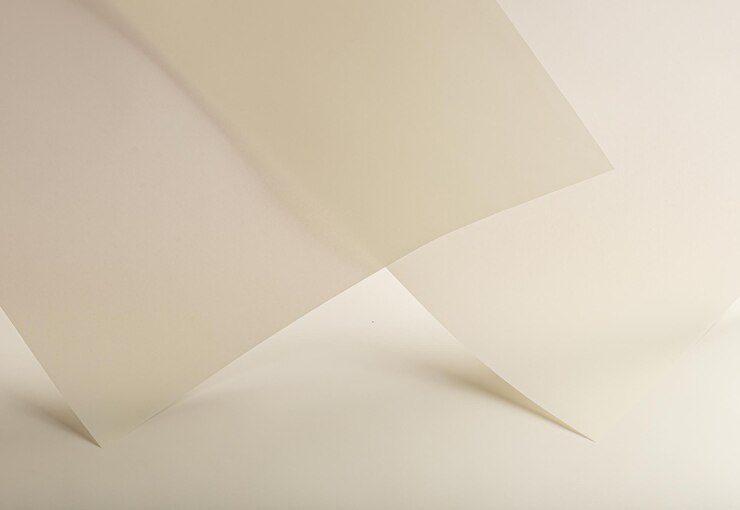 クリーム色のベージュ色の層とマットな滑らかな質感を持つ半透明のペラム紙の背景 柔らかい