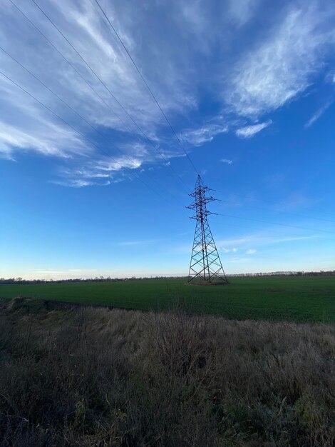 Transmissietoren in het groene veld onder de blauwe lucht