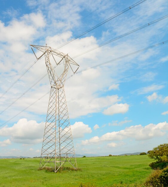 青空の下の田園地帯の送電鉄塔