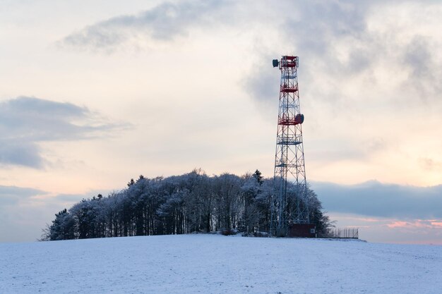 Transmitters and aerials on telecommunication tower sunset in snowy country