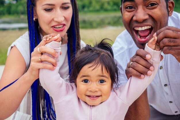 Transnationale interraciale moeder en vader wandelen met hun babymeisje van gemengd ras in het herfstpark