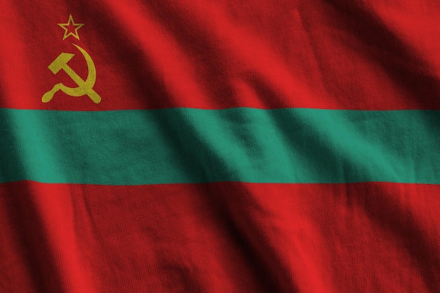 Transnistria flag with big folds waving close up under the studio light indoors The official symbols and colors in banner