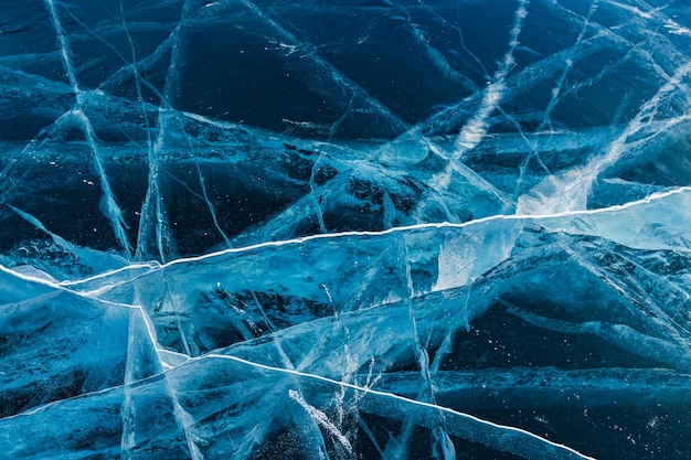 Transparant gebarsten blauw ijs op het Baikal-meer in de winter Abstracte winteraardachtergrond
