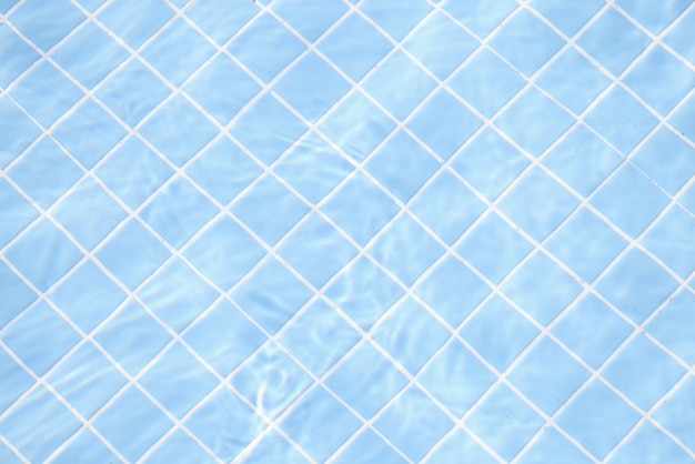 Transparant helder water in het zwembad op de achtergrond van blauwe tegels