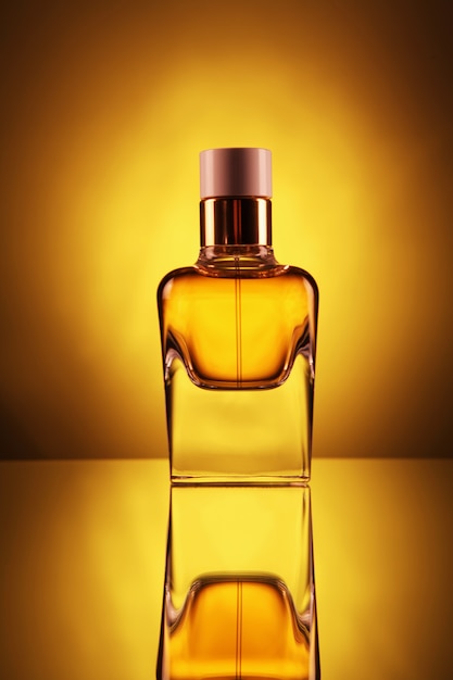 Transparante fles met parfum van gouden kleur op een geel